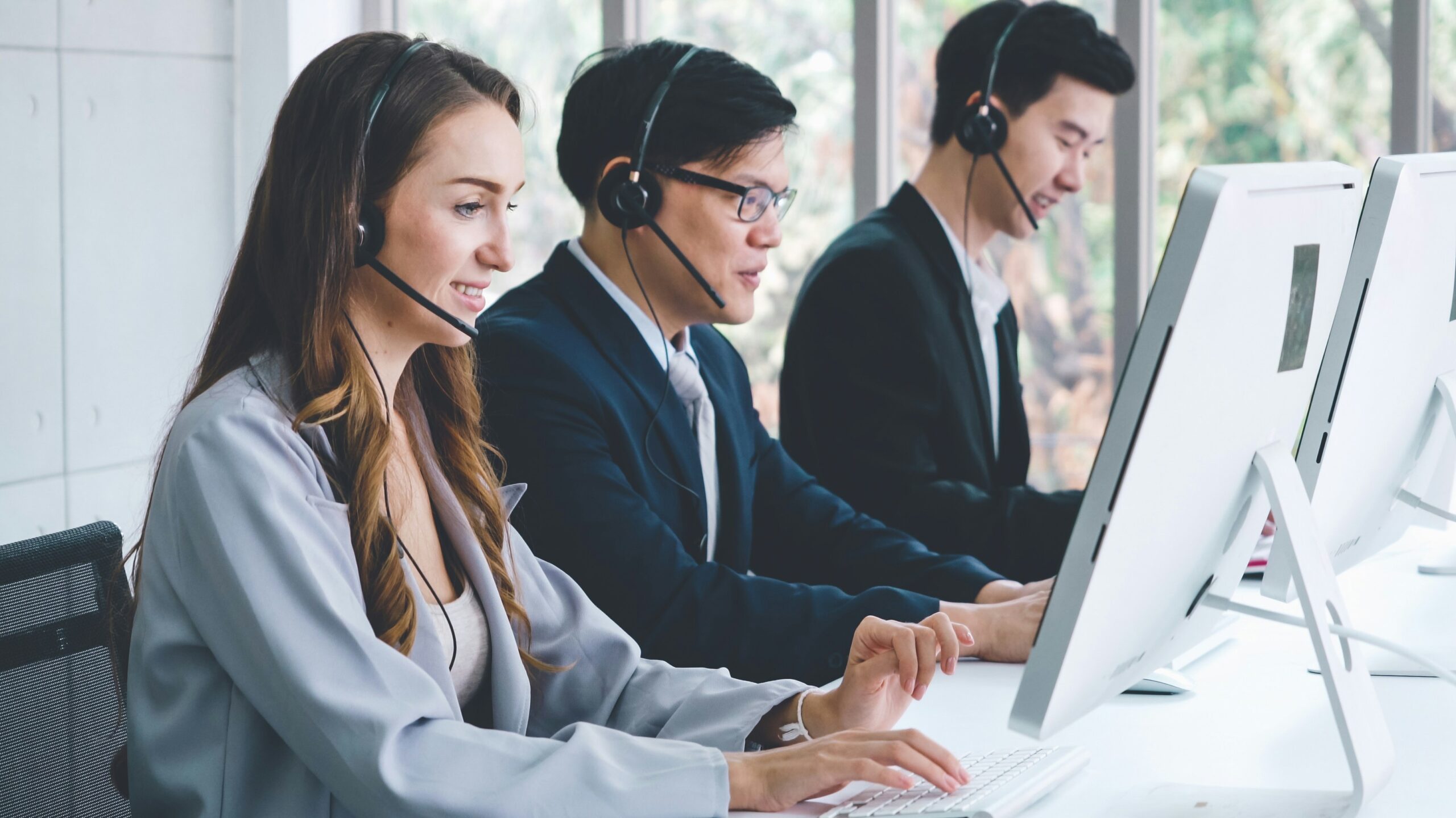 A team of professional contact center agents working at computers, providing 24/7 live answering to help businesses scale.